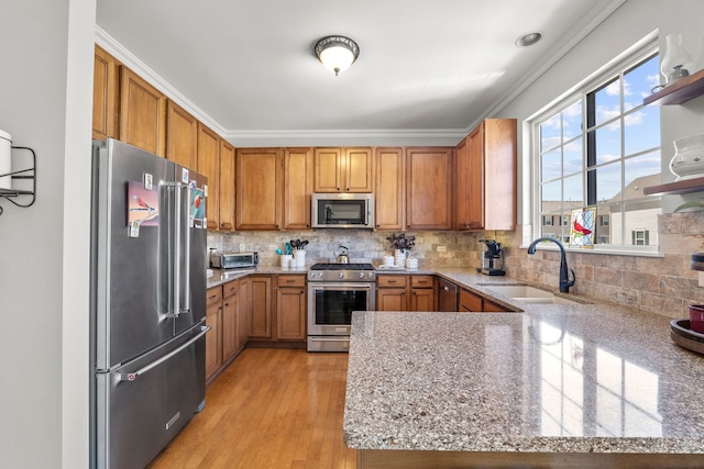 210 Station Park Cir, Grayslake, IL 60030 - kitchen with stainless steel appliances, a sink, brown cabinetry, light stone counters, and crown molding