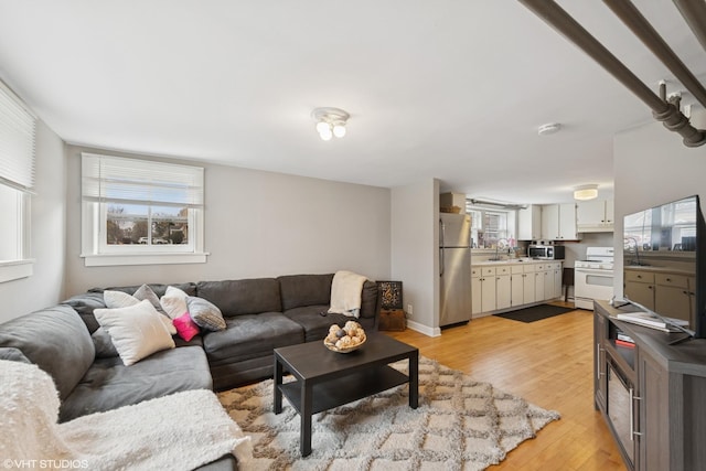 living area with plenty of natural light and light wood-style flooring