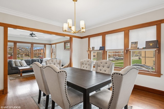 dining area featuring a chandelier, ornamental molding, wood finished floors, baseboards, and a ceiling fan