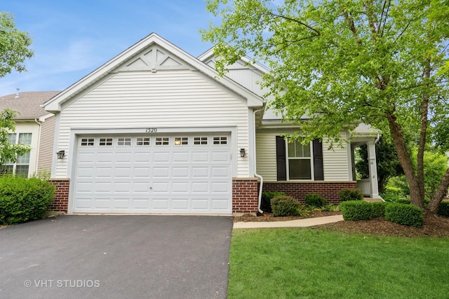 1520 Mansfield Dr, Aurora, IL 60502 - view of front of house with brick siding, asphalt driveway, a garage, and a front yard