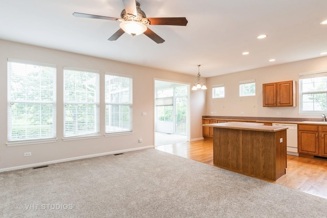 1520 Mansfield Dr, Aurora, IL 60502 - kitchen with white dishwasher, a center island, a ceiling fan, a chandelier, and brown cabinetry