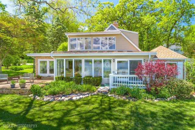 145 W Lake Shore Dr, Tower Lakes, IL 60010 - view of front of home featuring a chimney, a front yard, a patio, and a sunroom