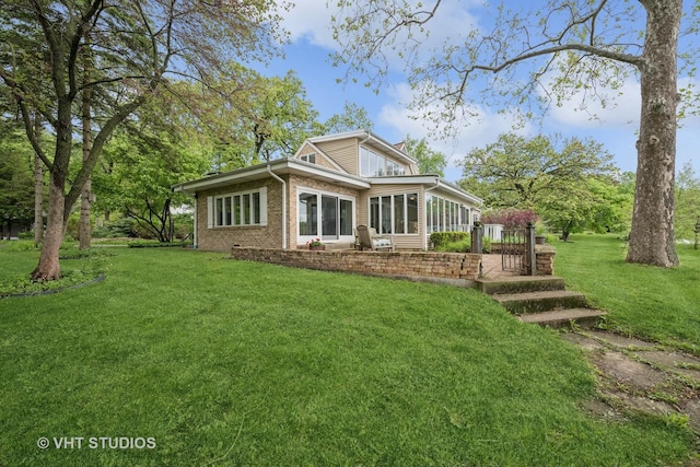145 W Lake Shore Dr, Tower Lakes, IL 60010 - rear view of property featuring a sunroom, a yard, and brick siding