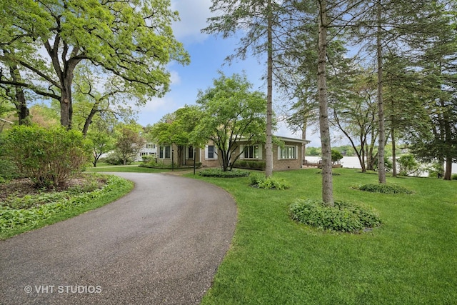 145 W Lake Shore Dr, Tower Lakes, IL 60010 - view of property hidden behind natural elements with brick siding, a front yard, and curved driveway