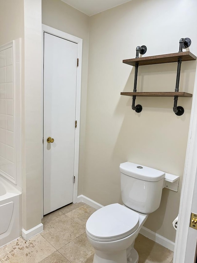5411 S Brookstone Dr, Rochelle, IL 61068 - bathroom featuring toilet, a tub to relax in, baseboards, and tile patterned floors