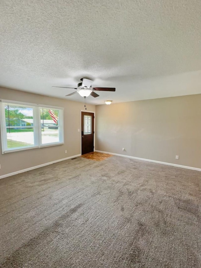 5411 S Brookstone Dr, Rochelle, IL 61068 - empty room with carpet floors, a textured ceiling, ceiling fan, and baseboards