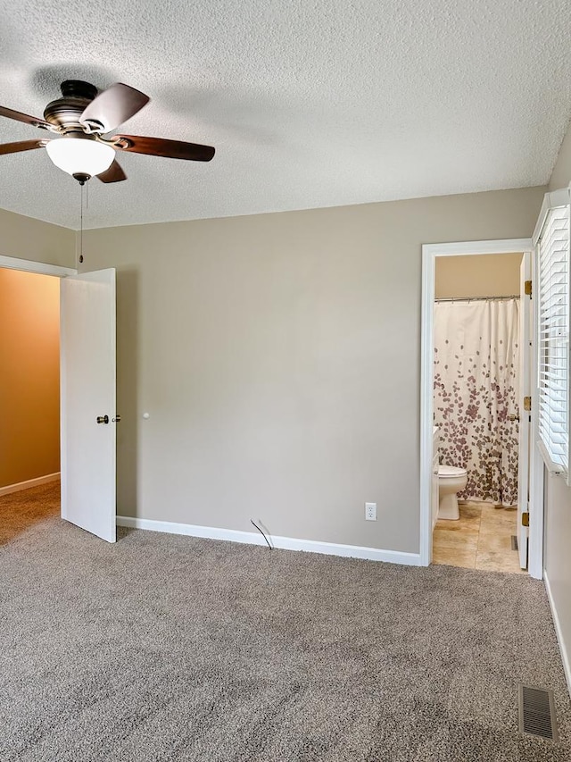 5411 S Brookstone Dr, Rochelle, IL 61068 - unfurnished bedroom with light colored carpet, a textured ceiling, ensuite bath, baseboards, and ceiling fan