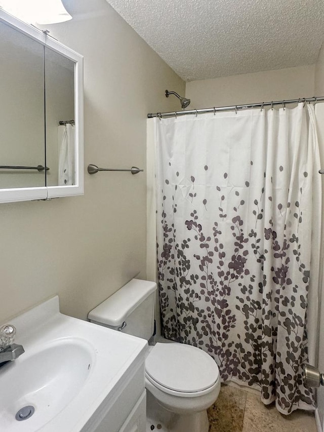 5411 S Brookstone Dr, Rochelle, IL 61068 - bathroom with a textured ceiling, toilet, vanity, and a shower with curtain