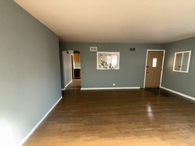 7825 S Pulaski Rd, Chicago, IL 60652 - unfurnished living room with arched walkways, baseboards, and wood finished floors