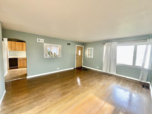 7825 S Pulaski Rd, Chicago, IL 60652 - unfurnished living room with wood finished floors, arched walkways, and baseboards