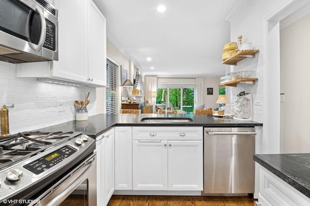 2842 N Southport Ave Unit 2, Chicago, IL 60657 - kitchen with stainless steel appliances, a sink, open shelves, a peninsula, and recessed lighting