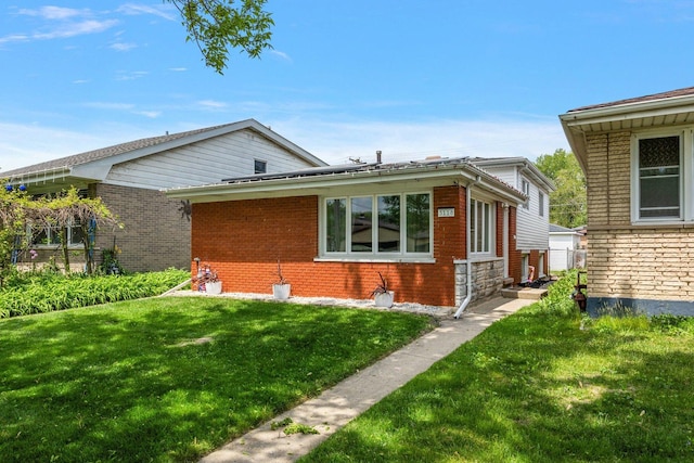 bungalow featuring a front yard and brick siding