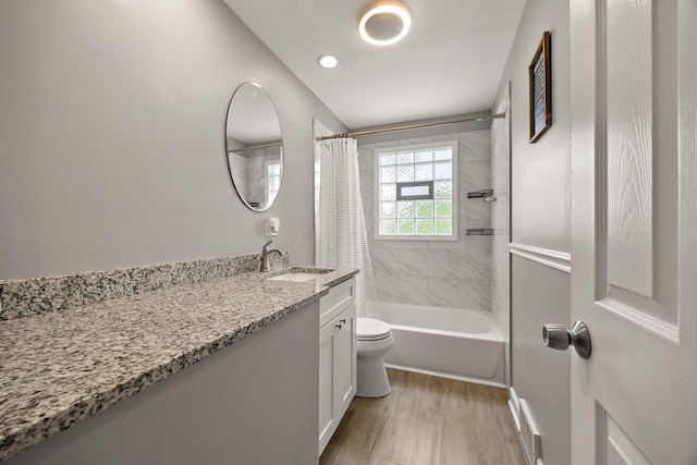 bathroom with wood finished floors, toilet, shower / bath combination with curtain, vanity, and baseboards