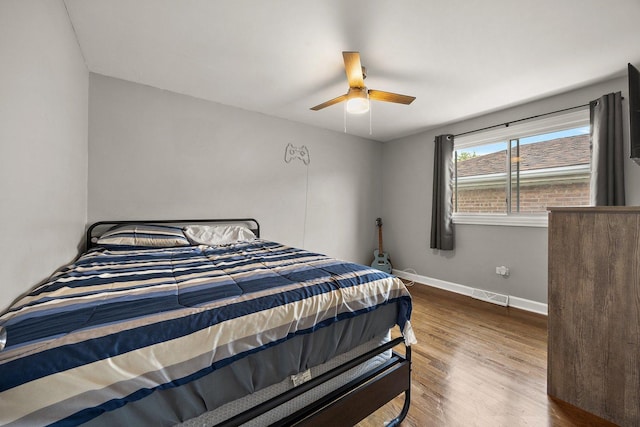 bedroom with wood finished floors, baseboards, and a ceiling fan