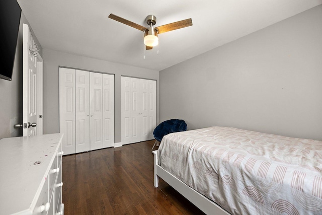 bedroom with multiple closets, dark wood finished floors, and a ceiling fan