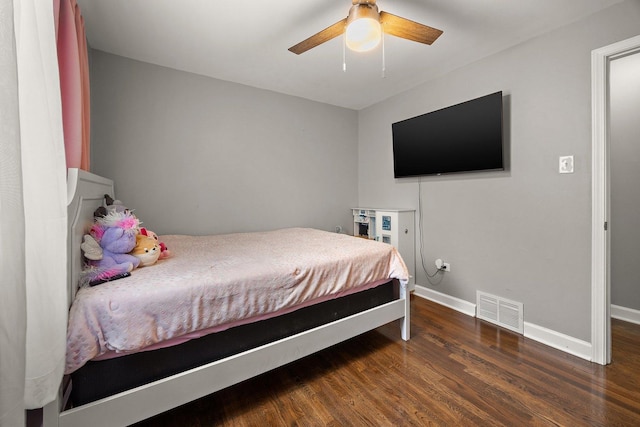 bedroom featuring wood finished floors, baseboards, and a ceiling fan