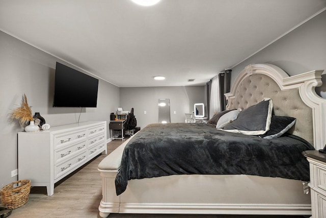 bedroom with light wood finished floors, baseboards, and crown molding