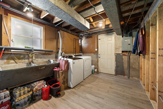 laundry room with washer and dryer, electric panel, and wood finished floors