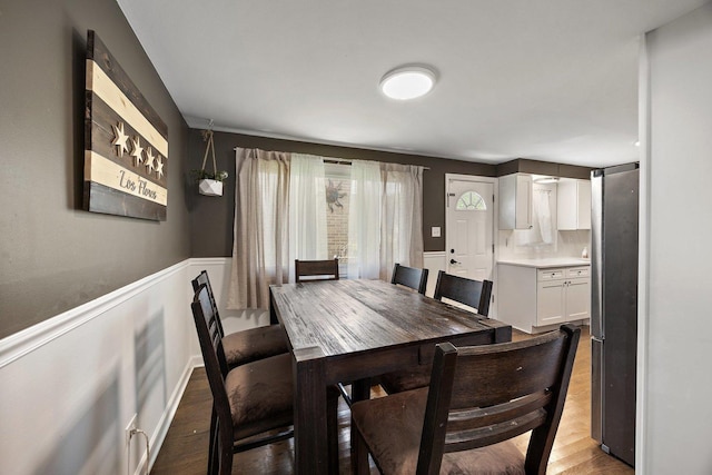 dining room featuring wood finished floors and wainscoting