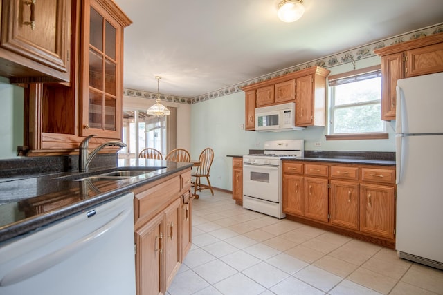 kitchen with white appliances, a sink, healthy amount of natural light, and glass insert cabinets