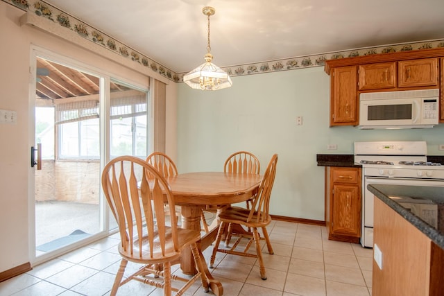 dining area featuring a chandelier, baseboards, and light tile patterned floors