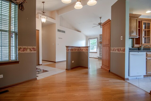 interior space featuring dishwasher, light wood-type flooring, beamed ceiling, a ceiling fan, and brown cabinets