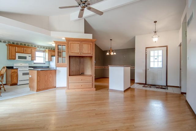 kitchen featuring white appliances, light wood-style floors, lofted ceiling, a kitchen island, and a ceiling fan
