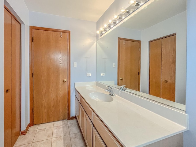 bathroom with vanity, tile patterned floors, and baseboards