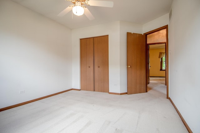 unfurnished bedroom featuring light colored carpet, a closet, a ceiling fan, and baseboards