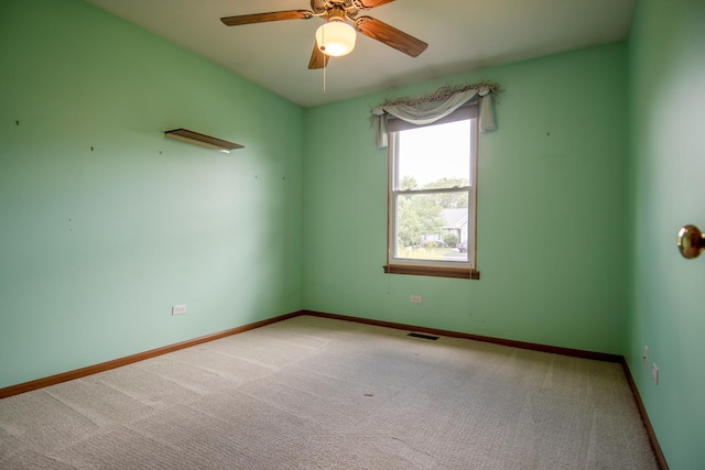 carpeted empty room with baseboards and a ceiling fan