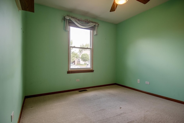 spare room featuring ceiling fan, carpet floors, and baseboards