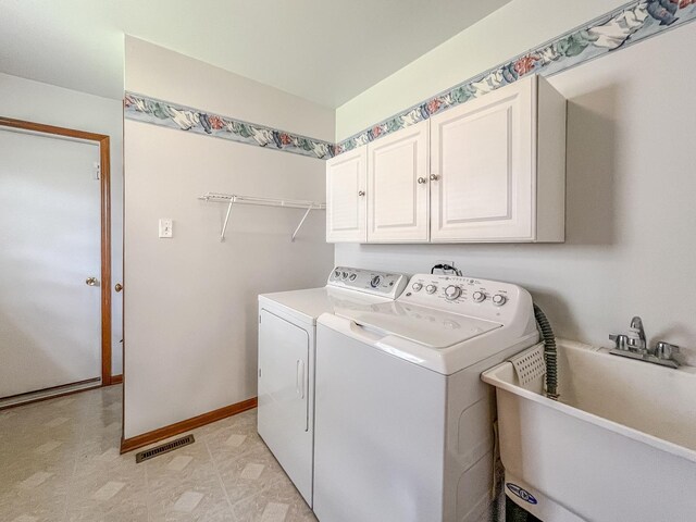laundry room with cabinet space, independent washer and dryer, and baseboards