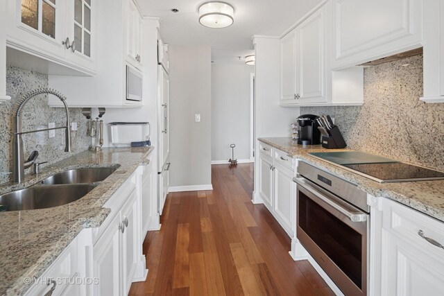 100 E Huron St Unit 4801, Chicago, IL 60611 - kitchen featuring stainless steel oven, a sink, backsplash, and black electric stovetop