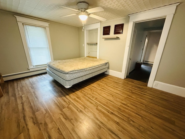 204 N Center St, Colfax, IL 61728 - bedroom featuring a baseboard heating unit, wood finished floors, baseboards, and a ceiling fan
