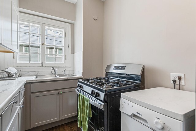408 N Prairie St Unit 3, Champaign, IL 61820 - kitchen with stainless steel range with gas cooktop, a sink, washer / clothes dryer, gray cabinetry, and dark wood-style floors