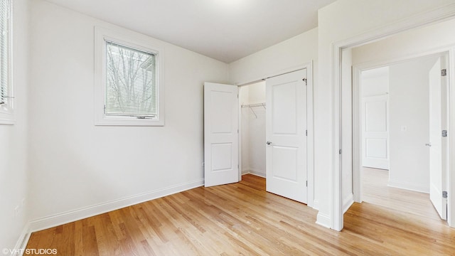 1416 S Emerald Ave, Chicago, IL 60607 - unfurnished bedroom with light wood finished floors, multiple windows, a closet, and baseboards
