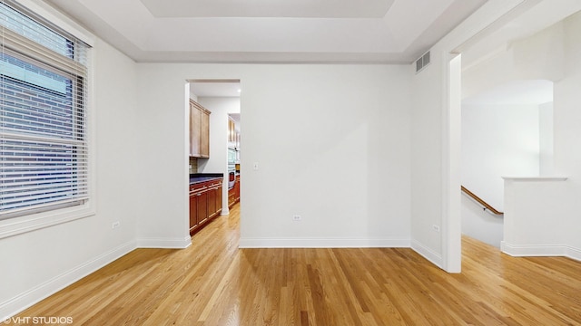 1416 S Emerald Ave, Chicago, IL 60607 - spare room with light wood-style flooring, a tray ceiling, and baseboards