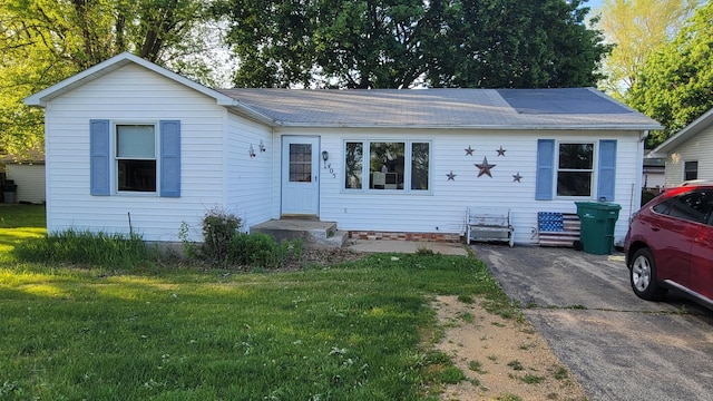 view of front facade featuring a front yard and roof with shingles