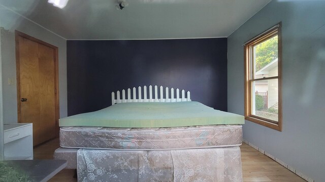 bedroom with wood finished floors and baseboards