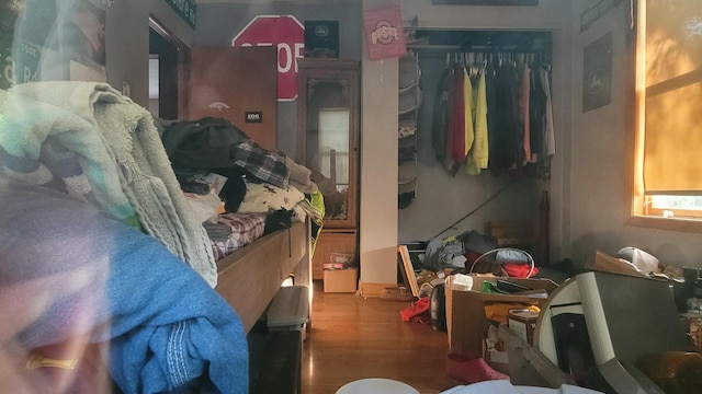 bedroom with wood finished floors and a closet