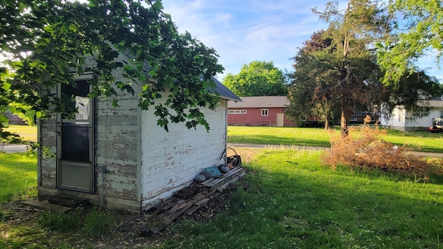 view of grassy yard featuring an outdoor structure and a storage shed