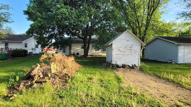 view of grassy yard with an outbuilding and a storage shed