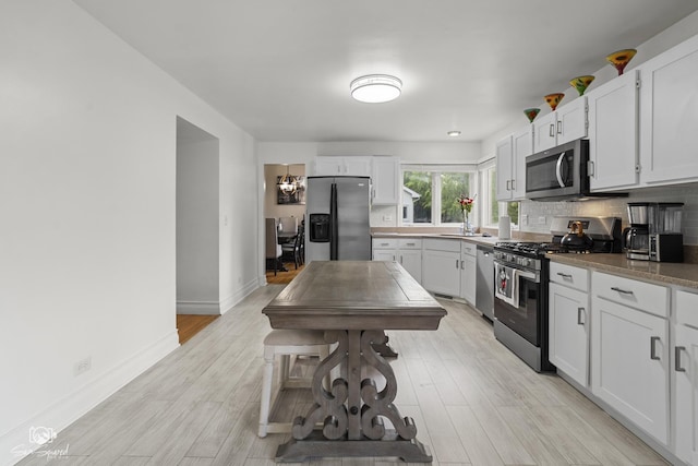 337 Aristocrat Dr, Bolingbrook, IL 60490 - kitchen featuring stainless steel appliances, decorative backsplash, light wood finished floors, and baseboards