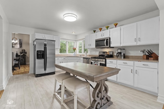 337 Aristocrat Dr, Bolingbrook, IL 60490 - kitchen featuring appliances with stainless steel finishes, light wood-style floors, white cabinets, and light countertops