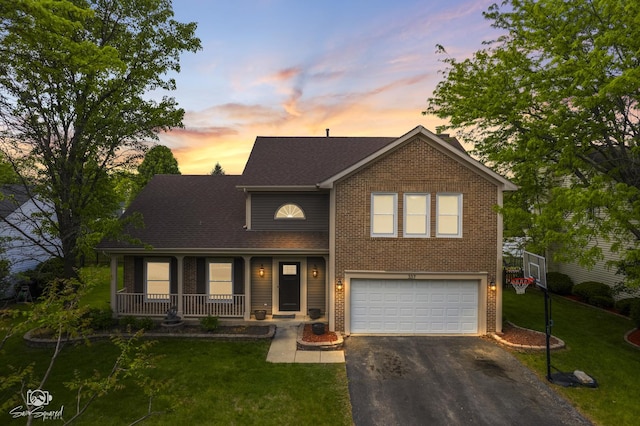 337 Aristocrat Dr, Bolingbrook, IL 60490 - view of front of house with driveway, covered porch, an attached garage, a yard, and brick siding