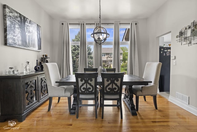 337 Aristocrat Dr, Bolingbrook, IL 60490 - dining room featuring a chandelier, light wood-style floors, and baseboards
