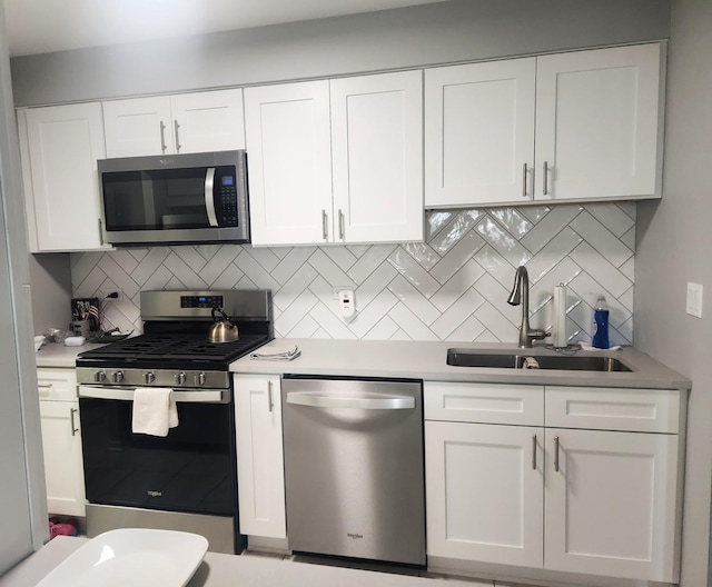 1001 N Mill St Unit 310, Naperville, IL 60563 - kitchen featuring appliances with stainless steel finishes, a sink, tasteful backsplash, white cabinets, and light countertops