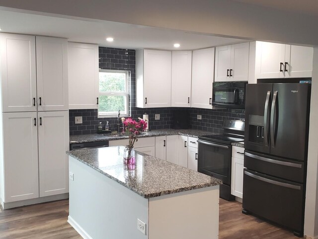 1020 Woodside Dr, Roselle, IL 60172 - kitchen with black appliances, a center island, wood finished floors, decorative backsplash, and recessed lighting