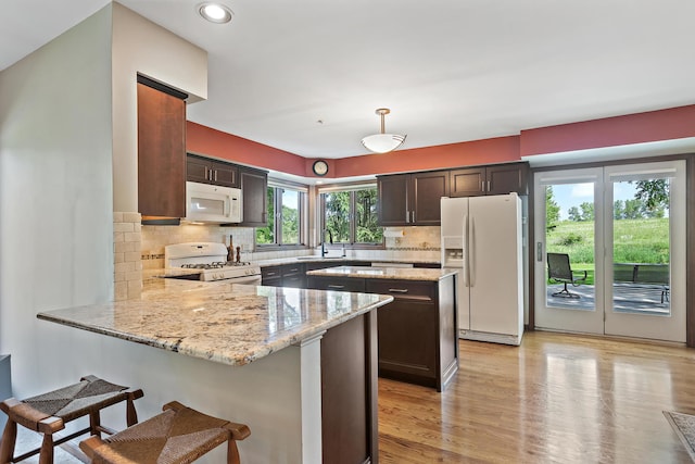 1224 Barclay Cir, Inverness, IL 60010 - kitchen featuring white appliances, a peninsula, light stone counters, light wood-style flooring, and recessed lighting