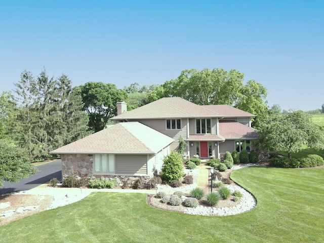 1224 Barclay Cir, Inverness, IL 60010 - traditional home featuring a front yard, stone siding, roof with shingles, and a chimney